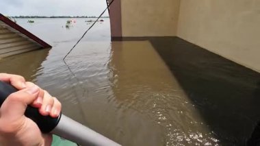 Hidroelektrik santrali patladıktan sonra kürek çeken gönüllülerin erkek elleri. Novaya Kakhovka kentindeki Dnipro nehrindeki baraj patlaması sonucu Kherson 'da sel baskını.