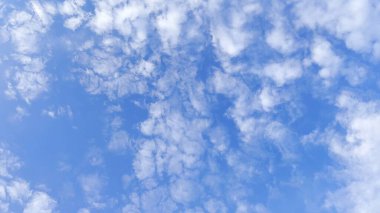 Yaz güneşli bir günde mavi gökyüzünde beyaz kabarık bulutların arkasında kamera hareket eder. Güzel bir doğa geçmişi var. Yavaşla.