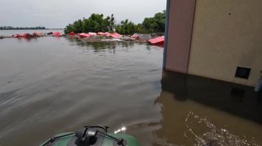 Hidroelektrik santrali patladıktan sonra kürek çeken gönüllülerin erkek elleri. Novaya Kakhovka kentindeki Dnipro nehrindeki baraj patlaması sonucu Kherson 'da sel baskını.