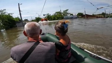 Kakhovka Hidroelektrik Santrali 'nin patlamasından sonra gönüllülerin insanları tekneye bindirmesi. Novaya Kakhovka kentindeki Dnipro nehrindeki baraj patlaması sonucu Kherson kasabasında sel baskını.