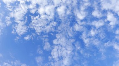 Yaz güneşli bir günde mavi gökyüzünde beyaz kabarık bulutların arkasında kamera hareket eder. Güzel bir doğa geçmişi var. Yavaşla.