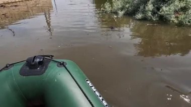 Hidroelektrik santrali patladıktan sonra kürek çeken gönüllülerin erkek elleri. Novaya Kakhovka kentindeki Dnipro nehrindeki baraj patlaması sonucu Kherson 'da sel baskını.