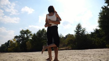 Mutlu çift kumsalda vakit geçiriyor. Güneşli bir günde deniz kıyısında sevgilisini öpen bir adam. Yazın sahil şeridinde dinlenen kaygısız aşıklar. Tatil ya da tatil kavramı. Yavaş çekim