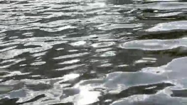 Yazın güneşle aydınlatılan göletin manzara yüzeyi. Güneşli bir günde deniz manzarası ve küçük dalgalar. Güzel yaz doğa manzarası. Huzur sahnesi kavramı. Yavaş çekim