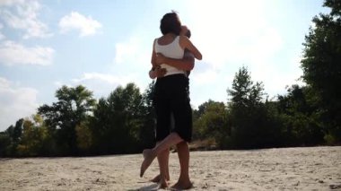 Mutlu çift kumsalda vakit geçiriyor. Güneşli bir günde deniz kıyısında sevgilisini öpen bir adam. Yazın sahil şeridinde dinlenen kaygısız aşıklar. Tatil ya da tatil kavramı. Yavaş çekim