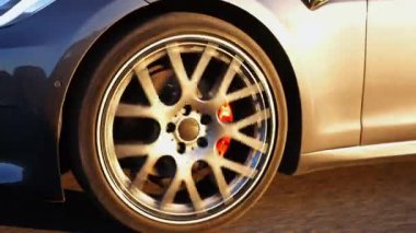 Güneşli bir günde şehir yolunda modern elektrikli otomobil sürüşü. Çevre dostu araba sürüşü otoyolda ilerliyor. Elektrikli araç boş otoyolda gidiyor. Yeşil yenilik kavramı.