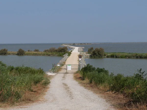 entrance gate of the the dirt cycle path on an embankment through Comacchio lagoons in the Po Delta Park