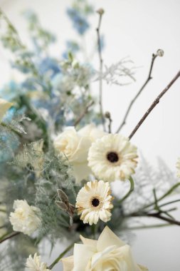 Close-up of a bouquet with white gerberas, roses, and greenery, highlighting the delicate textures and natural beauty of the blooms. Perfect for floral design enthusiasts or anyone seeking inspiration clipart