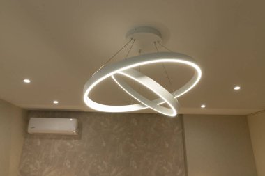 Modern bir apartman dairesinin içinde güzel tasarlanmış dairesel bir avize sergileniyor.