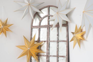 Delicate paper stars adorn a vintage mirror in a bright, airy interior creating a whimsical atmosphere full of charm and creativity clipart