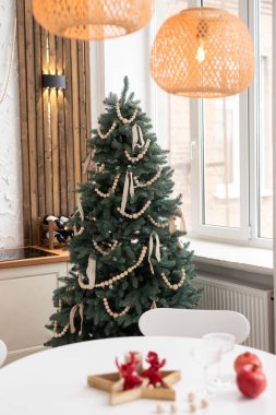 Çok güzel dekore edilmiş bir Noel ağacı. Kışın öğleden sonra sıcak, sıcak bir oturma odasında boncuk ve kurdelelerle süslenmiş.