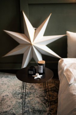 Elegant star decoration complements a cozy bedroom setting with stylish decor and warm ambiance in the late afternoon light clipart