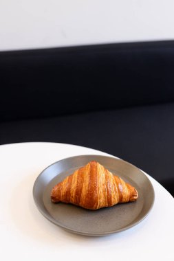 Dessert served on a minimalistic gray plate in a modern cafe setting with natural light