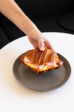 Modern bir kafe ortamında doğal ışığı olan minimalist gri bir tabakta servis edilen tatlı.