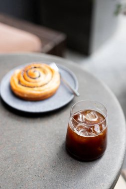 Sabahın köründe sıcak bir kafede tarçınlı çöreğin tadını çıkarırken tatlı bir ziyafetle dinleniyorum.