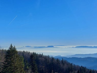 Pohorje dağının manzarası. Sis, tepeler ve mavi gökyüzü. Hocko Pohorje. Slovenya.