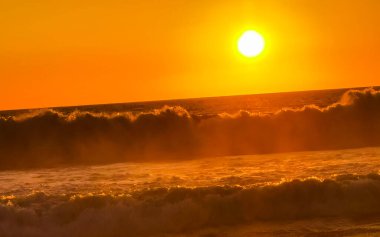 Sahilde sarı turuncu ve altın sarısı günbatımı ve Zicatela Puerto Escondido Oaxaca 'da tropikal doğada büyük dalga manzarası..
