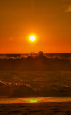 Sahilde sarı turuncu ve altın sarısı günbatımı ve Zicatela Puerto Escondido Oaxaca 'da tropikal doğada büyük dalga manzarası..