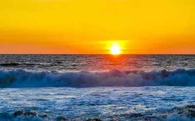 Sahilde sarı turuncu ve altın sarısı günbatımı ve Zicatela Puerto Escondido Oaxaca 'da tropikal doğada büyük dalga manzarası..