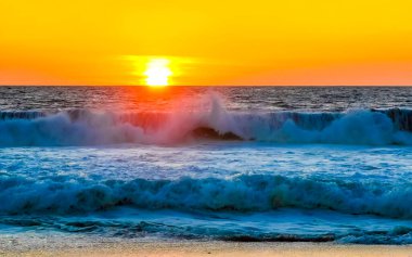 Sahilde sarı turuncu ve altın sarısı günbatımı ve Zicatela Puerto Escondido Oaxaca 'da tropikal doğada büyük dalga manzarası..