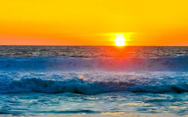 Sahilde sarı turuncu ve altın sarısı günbatımı ve Zicatela Puerto Escondido Oaxaca 'da tropikal doğada büyük dalga manzarası..