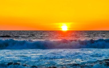 Sahilde sarı turuncu ve altın sarısı günbatımı ve Zicatela Puerto Escondido Oaxaca 'da tropikal doğada büyük dalga manzarası..