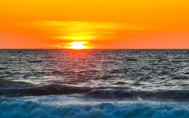 Sahilde sarı turuncu ve altın sarısı günbatımı ve Zicatela Puerto Escondido Oaxaca 'da tropikal doğada büyük dalga manzarası..