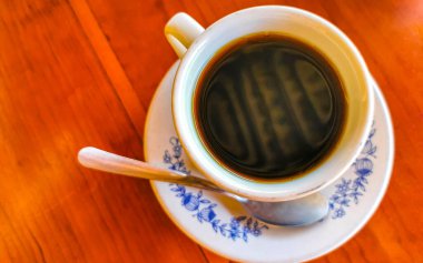 Zicatela Puerto Escondido Oaxaca Meksika 'daki El Cafecito' daki ahşap masada siyah kahve fincanı..