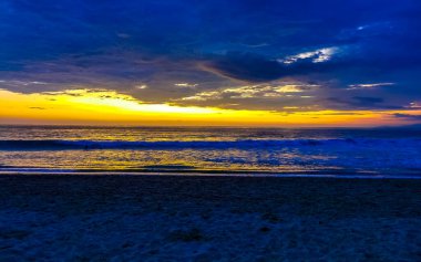Sahilde sarı turuncu ve altın sarısı günbatımı ve Zicatela Puerto Escondido Oaxaca 'da tropikal doğada büyük dalga manzarası..