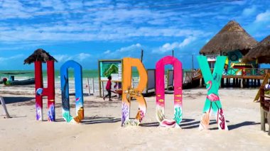 Holbox Mexico 21. December 2021 Colorful welcome letters and sign on the beautiful Holbox island sandbank and beach with waves turquoise water and blue sky in Quintana Roo Mexico.