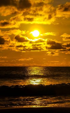 Sahilde sarı turuncu ve altın sarısı günbatımı ve Zicatela Puerto Escondido Oaxaca 'da tropikal doğada büyük dalga manzarası..