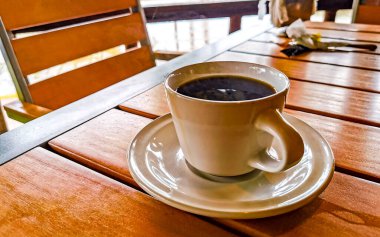 Zicatela Puerto Escondido Oaxaca Meksika 'daki restoranda bir fincan siyah kaşık ve tabakla birlikte kahve..