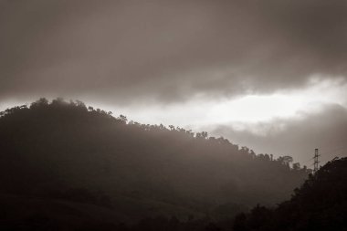 Brezilya 'daki Angra dos Reis dağlarının üzerinde güzel bir güneşin doğuşunun siyah beyaz resmi..