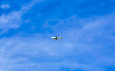 Playa del Carmen Quintana Roo Meksika 'da bulutlarla mavi gökyüzünde uçan uçak.