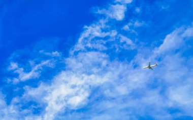 Playa del Carmen Quintana Roo Meksika 'da bulutlarla mavi gökyüzünde uçan uçak.