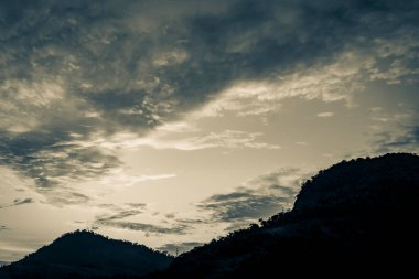 Brezilya 'daki Angra dos Reis dağlarının üzerinden renkli güzel bir güneşin doğuşunun eski siyah beyaz resmi.