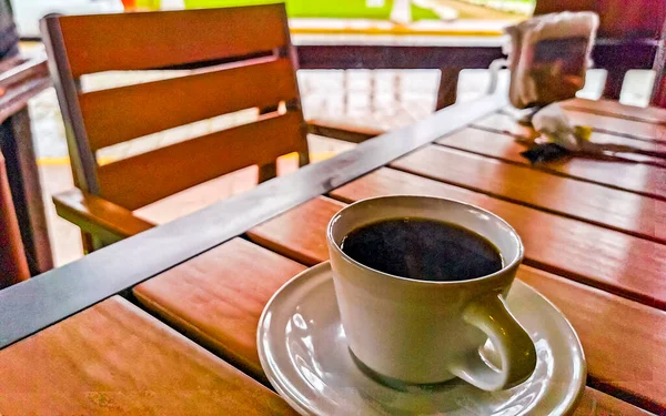 テーブルの上にスプーンとプレートとアメリカーノブラックコーヒーのカップとZicatelaプエルトエスコンディドオアハカメキシコのレストランで飲む — ストック写真