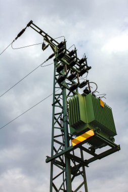 Schwanewede Osterholz Almanya 'sındaki Harrier Kum Adası' nın kara bulutları üzerinde yeşil elektrik direği.