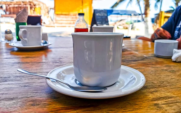 Cup of americano black coffee with spoon and plate on table food and drink in the restaurant on Isla Holbox island in Quintana Roo Mexico.