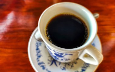 Zicatela Puerto Escondido Mexico 'daki El Cafecito' daki ahşap masada siyah kahve fincanı..