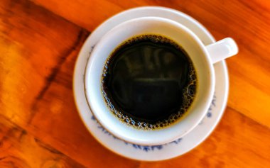 Zicatela Puerto Escondido Mexico 'daki El Cafecito' daki ahşap masada siyah kahve fincanı..