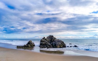 Zicatela Puerto Escondido Oaxaca 'daki plajda inanılmaz güzel büyük sörfçü dalgaları ve kayalar..