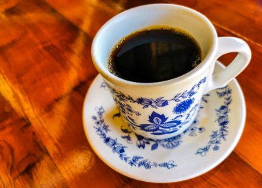 Zicatela Puerto Escondido Mexico 'daki El Cafecito' daki ahşap masada siyah kahve fincanı..