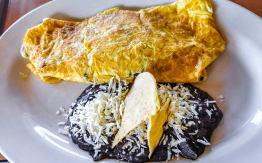 Meksika omleti, siyah fasulye soslu ve beyaz tabakta Meksika usulü omlet ve Meksika usulü Puerto Escondido Oaxaca..