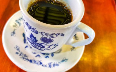 Zicatela Puerto Escondido Mexico 'daki El Cafecito' daki ahşap masada siyah kahve fincanı..