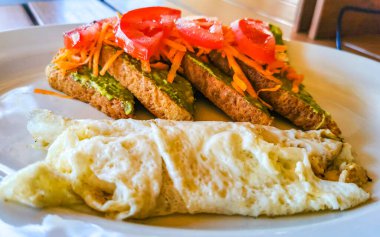 Meksika omleti ve siyah fasulyeli yumurta patates ve beyaz tabakta nachos Zicatela Puerto Oaxaca Meksika 'da El Cafecito' da..