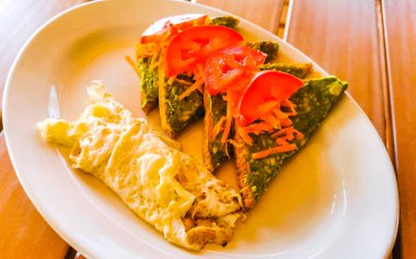 Meksika omleti ve siyah fasulyeli yumurta patates ve beyaz tabakta nachos Zicatela Puerto Oaxaca Meksika 'da El Cafecito' da..