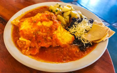 Meksika omleti ve siyah fasulyeli yumurta patates ve beyaz tabakta nachos Zicatela Puerto Oaxaca Meksika 'da El Cafecito' da..