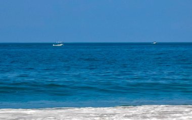 Zicatela Puerto Escondido Oaxaca 'da güneş plajı insanları dalgalar ve tekneler.