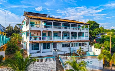 Zicatela Puerto Escondido Oaxaca Meksika 'daki palmiye ağaçları arasında cennetteki oteller ve binalar.